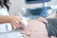 doctor-using-ultrasound-equipment-screening-of-pregnant-woman.png